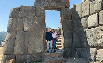 Entrada de piedra en Sacsayhuaman, Cusco: viajeros en el sitio arqueologico
